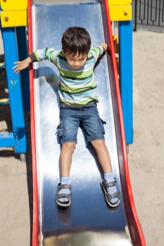 Cute boy  playing on slide