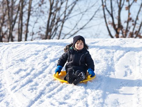 Boy on sleigh. Sledding at winter time