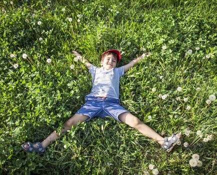 4 years old boy lying on the grass