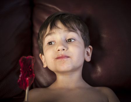 Close Up of Young Boy Eating A Lollipop