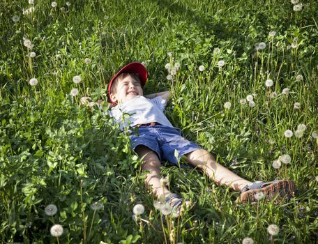 4 years old boy lying on the grass