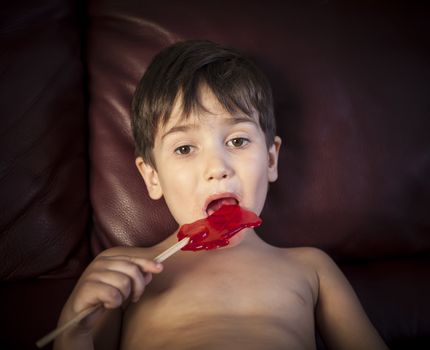 Close Up of Young Boy Eating A Lollipop