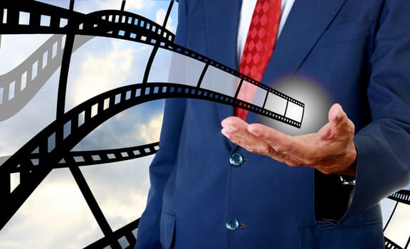 Film strip in businessman hand, Cinema industrial