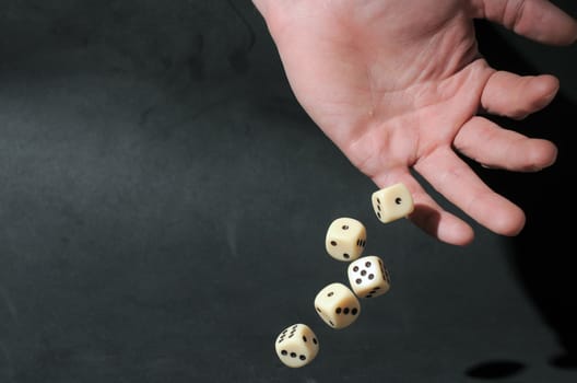 An Hand Play Dice on a Dark Background