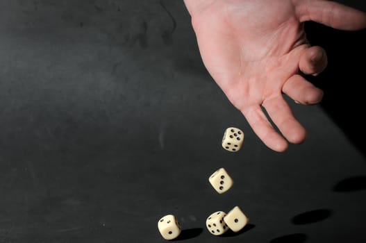 An Hand Play Dice on a Dark Background