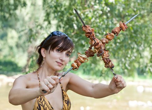 Young woman on a picnic with grilled meaton a picnic with grilled meat