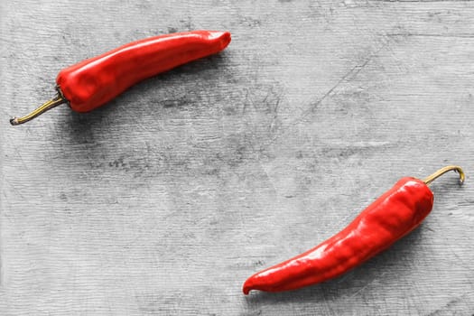 Red hot chili peppers on old wooden table surface texture background