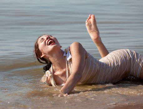 Young happy woman enjoys sunny day at the beach.