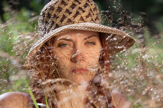 Young woman in the grass on natural background in the sunlight