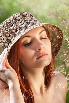 Young woman in the grass on natural background in the sunlight
