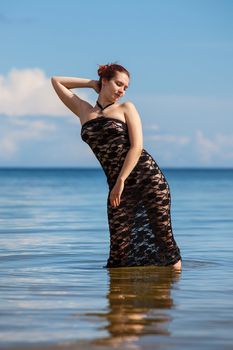 woman in black lace dress against the sea
