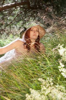 Young woman in the grass on natural background in the sunlight