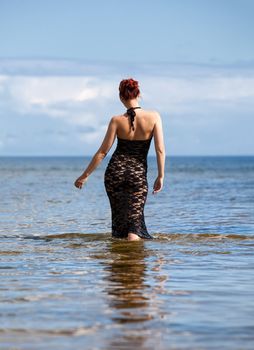 woman in black lace dress against the sea