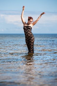 woman in black lace dress against the sea