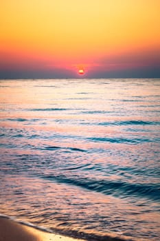 Soft sea ocean waves wash over golden sand background. Sunset, sunrise, sun