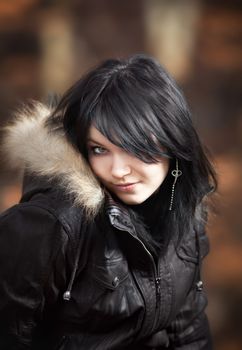 Young woman in a leather jacket looking with interest