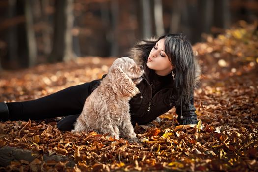 Girl and american cocker spaniel in the autumn forest