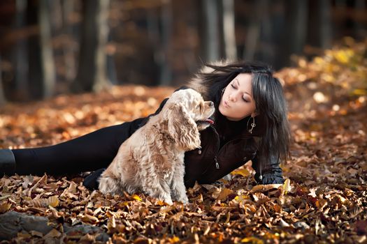 Girl and american cocker spaniel in the autumn forest