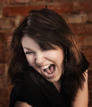 Joyful young girl on brick wall background