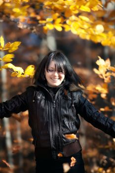 Happy young woman in autumn forest