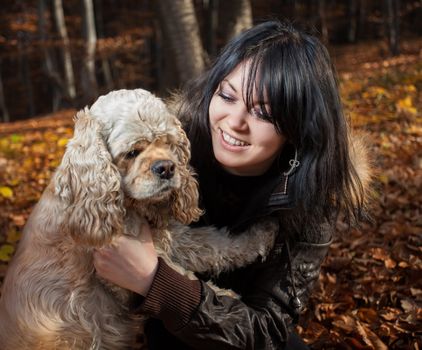 Girl and american cocker spaniel in the autumn forest