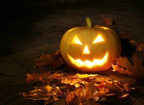 Halloween pumpkin glowing candle light in dark garden