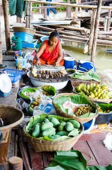 AYUTTHAYA - SEPTEMBER 22:  Tourists and people sell food items at Ayothaya Floating Market on September 22, 2013 in Ayutthaya, Thailand. Ayothaya Floating Market  is a very popular tourist attraction.