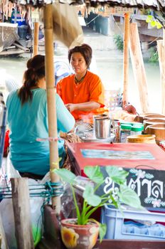 AYUTTHAYA - SEPTEMBER 22:  Tourists and people sell food items at Ayothaya Floating Market on September 22, 2013 in Ayutthaya, Thailand. Ayothaya Floating Market  is a very popular tourist attraction.