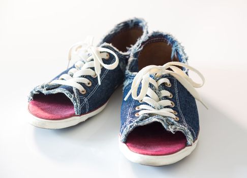 Blue denim shoes with laces, on white background.