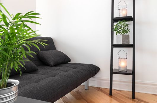 Living room with gray sofa, decorated with plants and lanterns.