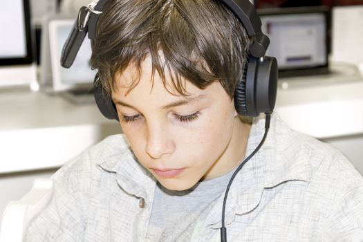 Portrait of a sweet young boy listening to music on headphones