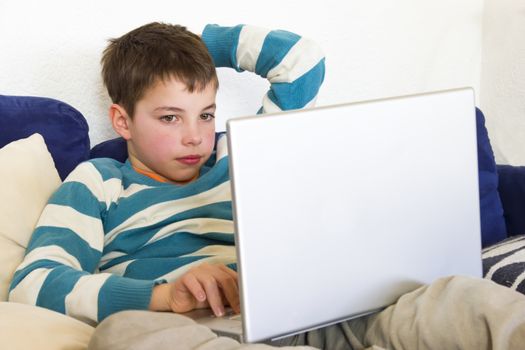 Thoughtful kid work on a computer through the wireless network