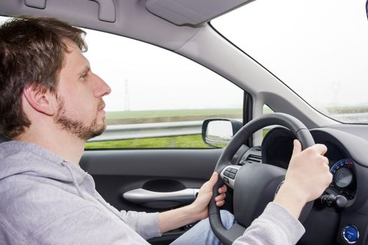 a man driving a car in the rain