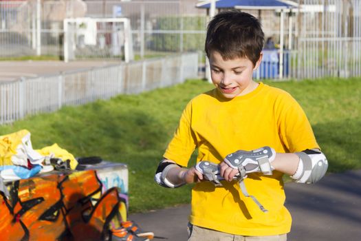 The boy puts on intently roller protection kit