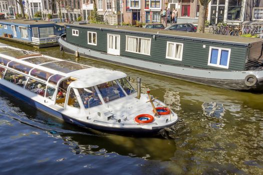 View on the houseboats with cruiseboat in Amsterdam the Netherlands