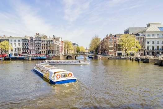 View on the houseboats with cruiseboat in Amsterdam the Netherlands