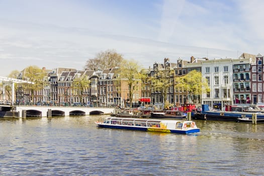 View on the houseboats with cruiseboat in Amsterdam the Netherlands