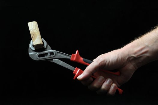 Pliers and a Hand on a Black Background