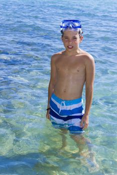 Cute eleven years old boy staying in the sea