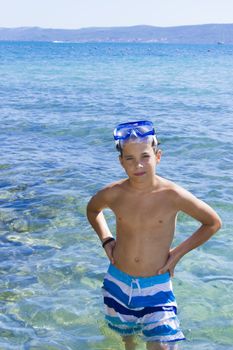 Cute eleven years old boy staying in the sea