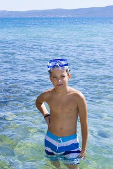 Cute eleven years old boy staying in the sea