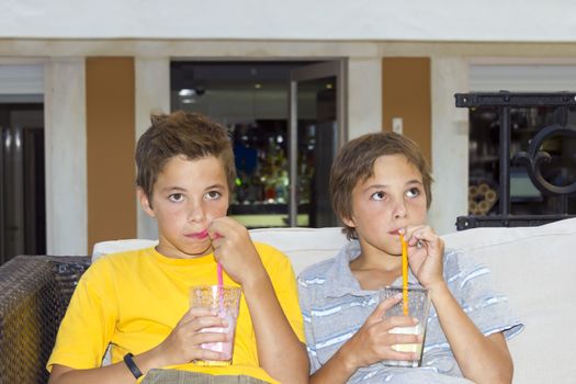 Adorable boys with glasses of milkshake