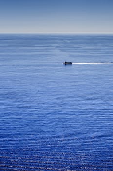 Sea landscape under the sun with waves, reflections and distant ships