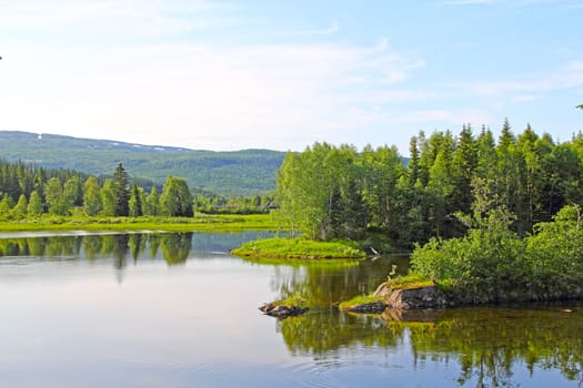 Beautiful view on calm lake and mountains in Norway at summer