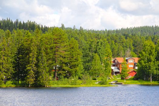 Small swedish village on the bank of calm lake in summer