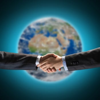 handshake of two businessmen on the background of the planet earth. Elements of this image are furnished by NASA