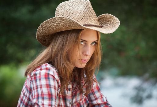 Sexy cowgirl. Young woman portrait in a hat