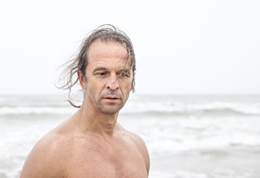 Portrait of middle-aged men with long hair on the sea background