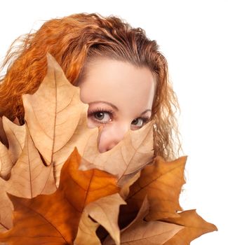 Redhead girl with dry autumn leaves