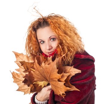 Redhead girl with dry autumn leaves